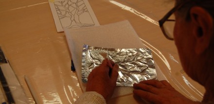 Jedna z uczestniczek w trakcie tworzenia srebrnej płaskorzeźby przedstawiającej drzewo.