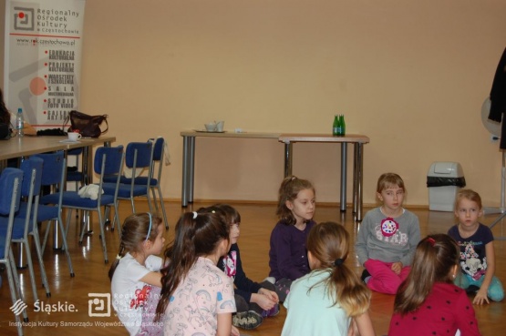 Dzieci w trakcie wykładu, siedzą na podłodze.