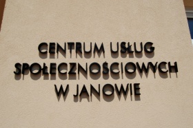 Zbliżenie na napis umieszczony na elewacji budynku - Centrum Usług Społecznościowych w Janowie.  