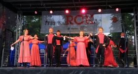 Zespół w różowych strojach tańczy poloneza