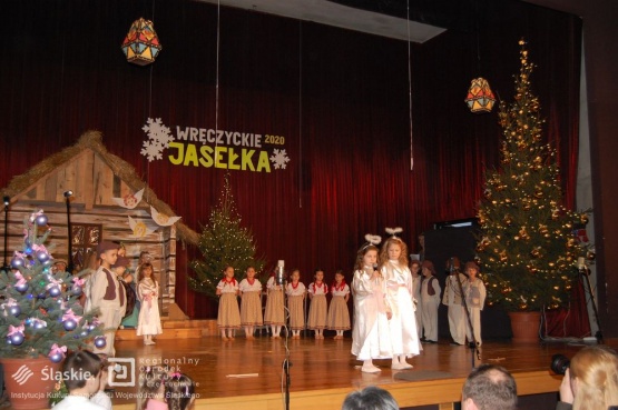 Przedstawienie Jasełek- dzieci przebrane za aniołki, pastuszków oraz górali stoją na scenie.