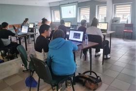 Panorama sali w której odbywają się zajęcia z grafiki komputerowej, widoczni uczestnicy, którzy pracują na laptopach.