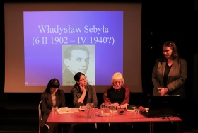 Dyskusja uczestników z gośćmi, w tle prezentacja dotycząca życia Władysława Sebyły i jego portret.
