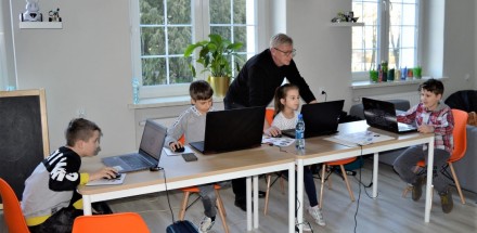 Prowadzący zajęcia instruuje uczestników warsztatów z grafiki komputerowej.