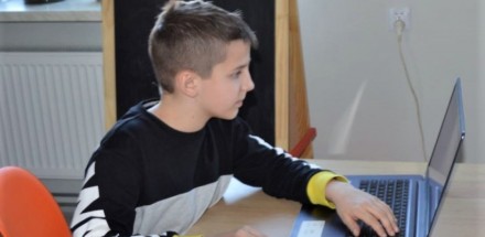 Uczestnik warsztatów grafiki komputerowej siedzi przed laptopem.