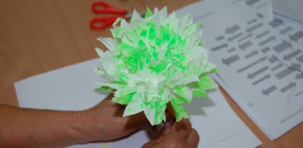 Biało-zielony kwiat z papieru stworzony w ramach zajęć plastycznych.