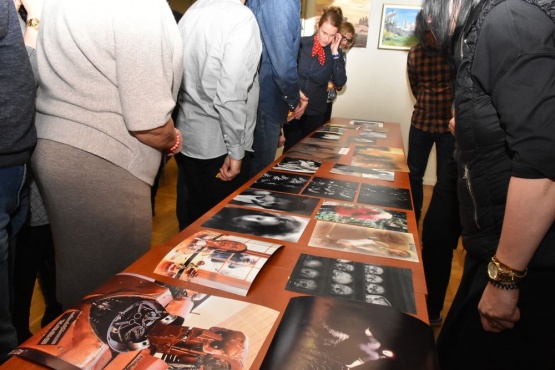 Zbliżenie na stół na którym rozłożone są zdjęcia wykonane przez uczestników konkursu - zdjęcia kolorowe oraz czarno-białe.
