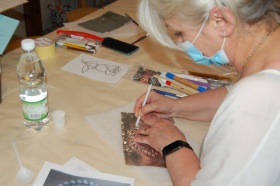 Kobieta używająca ołóka do odrysowania kształtu ozdoby.