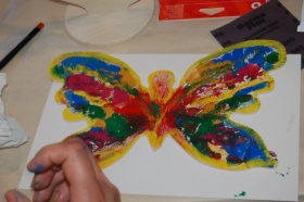 Zbliżenie na prace plastyczną wykonaną przez uczestniczkę warsztatów malarskich - kolorowy motyl.