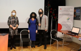 Jolanta Rycerska - zdjęcie z uczestnikiem prelekcji. Oboje mają założone czarne maski.