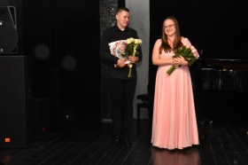 Mężczyzna i kobieta trzymają kwiaty.