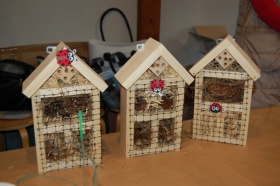 Pokazany mały drewniany domek z siankiem. Jest przykryty siateczką, a dla ozdoby zamieszczono tam biedronkę.