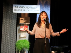 Kobieta stoi na scenie przy mikrofonie - 67. Ogólnopolski Konkurs Recytatorski.