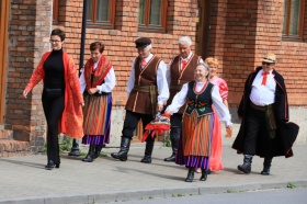 Osoby w strojach folklorystycznych idące ulicą