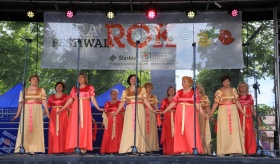 Kobiety w sukniach brzoskwiniowych i złotych występujące na scenie