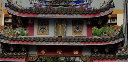 Tajwan - zdjęcie budynku. Dominuje wiele kolorów oraz egzotyczna roślinność. Na samej górze budynku dwa zielone smoki łączą się w herb.
