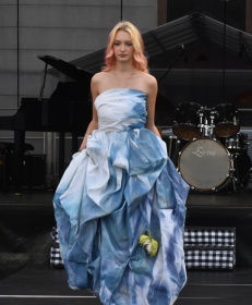 Pokaz mody- kobieta w niebieskiej sukni na scenie.