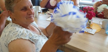 Uczestniczki warsztatów wykonują prace plastyczne - papierowe kwiaty.